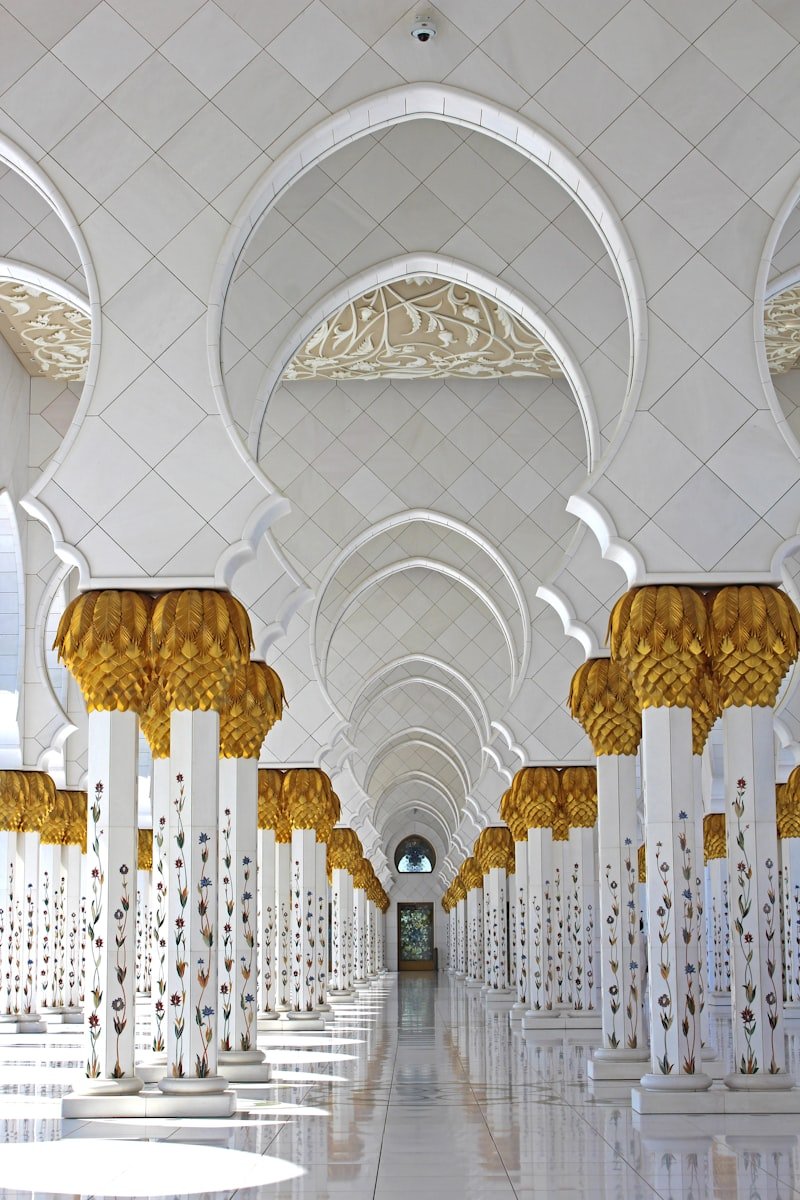 White marble colonnade of a grand mosque with gold details